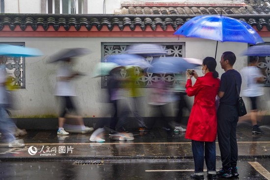 6月7日，在浙江省2023年普通高校招生考試鎮(zhèn)海中學(xué)考點，家長冒雨目送子女進入考場。人民網(wǎng) 章勇濤攝