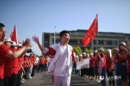 6月7日，在北京市人大附中通州校區(qū)考點，考生與送考老師擊掌加油。人民網(wǎng)記者 翁奇羽攝