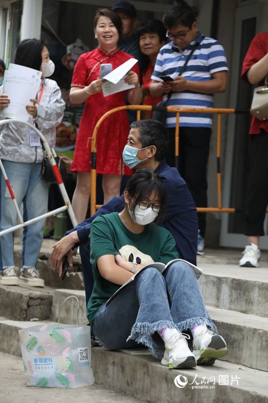 6月7日，沈陽市第一中學(xué)，學(xué)子靠在父親身邊做最后的沖刺。人民網(wǎng) 周頌雪攝