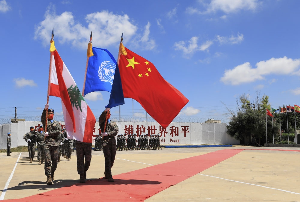 在黎巴嫩南部辛尼亞村的中國維和部隊營區(qū)，中國維和部隊官兵在受勛后通過觀禮臺（2022年7月1日攝）。聯(lián)合國駐黎巴嫩臨時部隊（聯(lián)黎部隊）當日授予中國第20批赴黎巴嫩維和部隊全體410名官兵聯(lián)合國“和平勛章”，以表彰他們?yōu)槔璋湍勰喜康貐^(qū)和平穩(wěn)定作出的突出貢獻。新華社記者 劉宗亞 攝