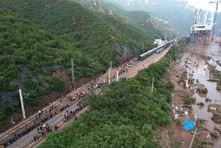 8月2日，受困列車(chē)旅客在救援人員幫助下徒步趕往轉(zhuǎn)運(yùn)客車(chē)（無(wú)人機(jī)照片）。新華社記者 張晨霖 攝