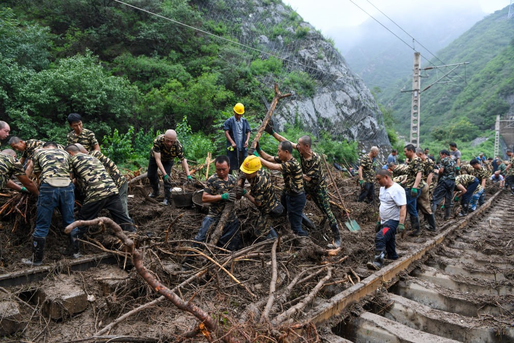 8月1日，在北京市門(mén)頭溝區(qū)水峪嘴村附近一段被阻斷的鐵路線上，中鐵六局工作人員在清理軌道上的雜物，全力恢復(fù)交通。新華社記者 鞠煥宗 攝