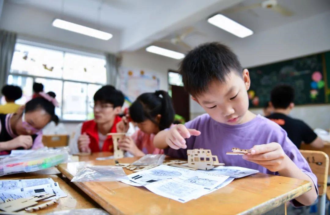 △今年7月，在浙江余姚市舜北小學(xué)暑托班內(nèi)，孩子們制作太陽能科學(xué)實驗裝置。