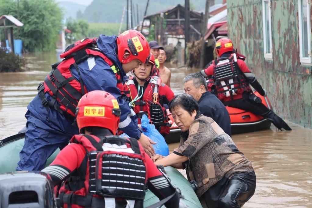 8月4日，在黑龍江省尚志市一面坡鎮(zhèn)萬(wàn)山村，哈爾濱市森林消防支隊(duì)的消防員在解救被困村民。新華社發(fā)