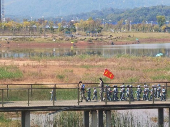 10月24日，秋游的幼兒園小朋友在老師帶領(lǐng)下走在清水塘公園里的木橋上。本報(bào)記者 常雯宜攝