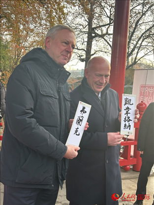 柏林市長(zhǎng)韋格納（右）、動(dòng)物園監(jiān)事會(huì)主席布魯克曼（左）手持中國(guó)文化中心工作人員現(xiàn)場(chǎng)手書的中文名字。人民網(wǎng)記者 徐馨攝