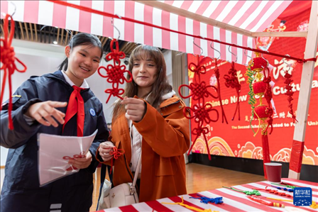 1月28日，復(fù)旦大學(xué)第二附屬學(xué)校學(xué)生（左）為美國馬斯卡廷中學(xué)學(xué)生（右）介紹中國結(jié)。 新華社記者 王翔 攝