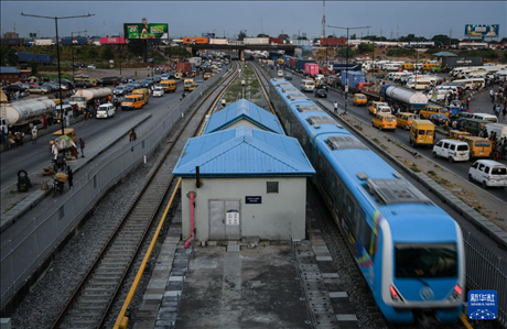 3月4日，在尼日利亞拉各斯，一列輕軌藍(lán)線列車(chē)行駛至公路交通擁堵路段附近。新華社記者 韓旭 攝