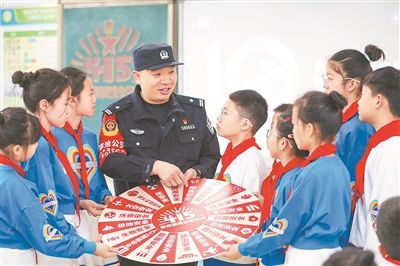 圖為公安民警給學(xué)生們講解國家安全知識。張鷹攝