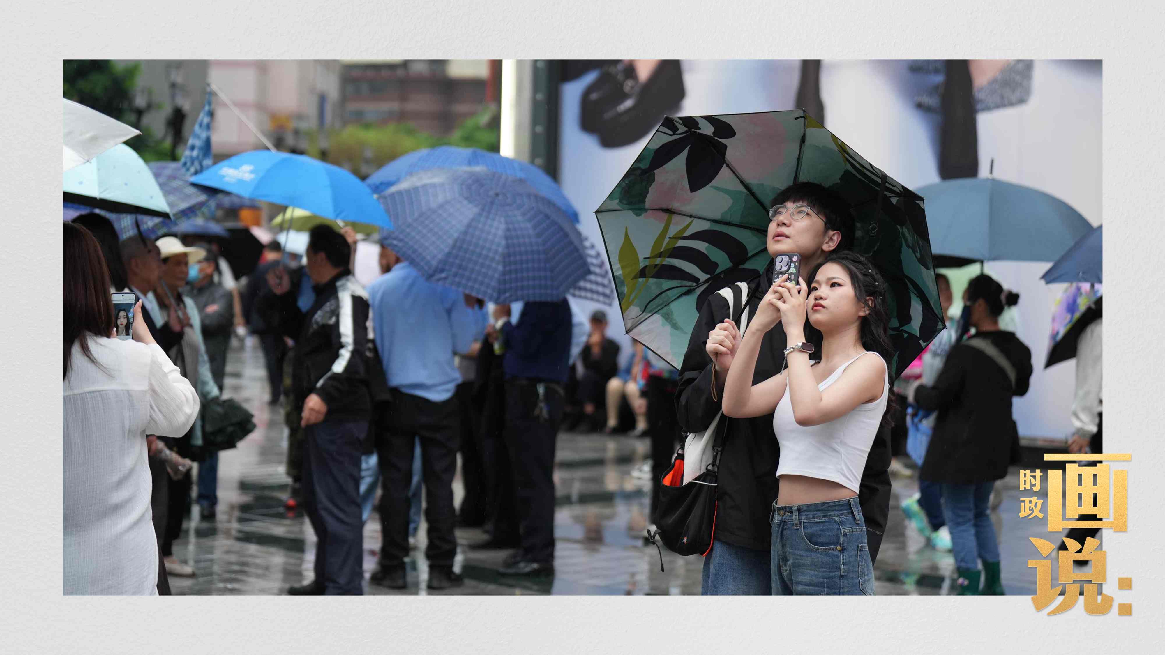 △細雨中的解放碑步行街，騎在父親肩膀的小女孩好奇張望。