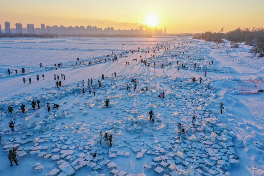 2024年1月7日，在封凍的松花江哈爾濱段，游客在日落時分的“鉆石海”游玩（無人機照片）。新華社記者 謝劍飛 攝