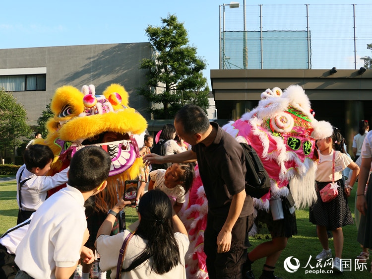 孩子們好奇地圍觀舞獅。人民網(wǎng) 許可攝