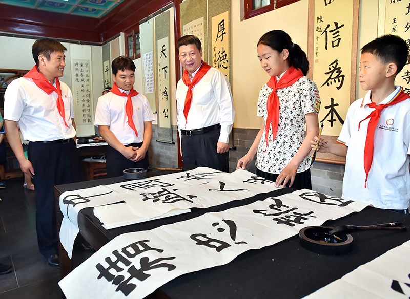 2014年5月30日，習(xí)近平總書記來到北京市海淀區(qū)民族小學(xué)，參加慶?！傲弧眹H兒童節(jié)活動(dòng)。這是總書記觀看學(xué)生書寫的毛筆字。