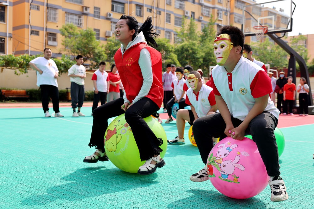 2024年5月17日，在山東省棗莊市市中區(qū)特殊教育中心，青年志愿者與智力障礙學(xué)生一起做游戲。新華社發(fā)（孫中喆攝）