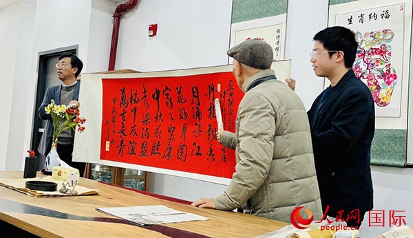 旅秘書法家向現(xiàn)場(chǎng)觀眾展示書法作品。人民網(wǎng)記者 宋亦然攝