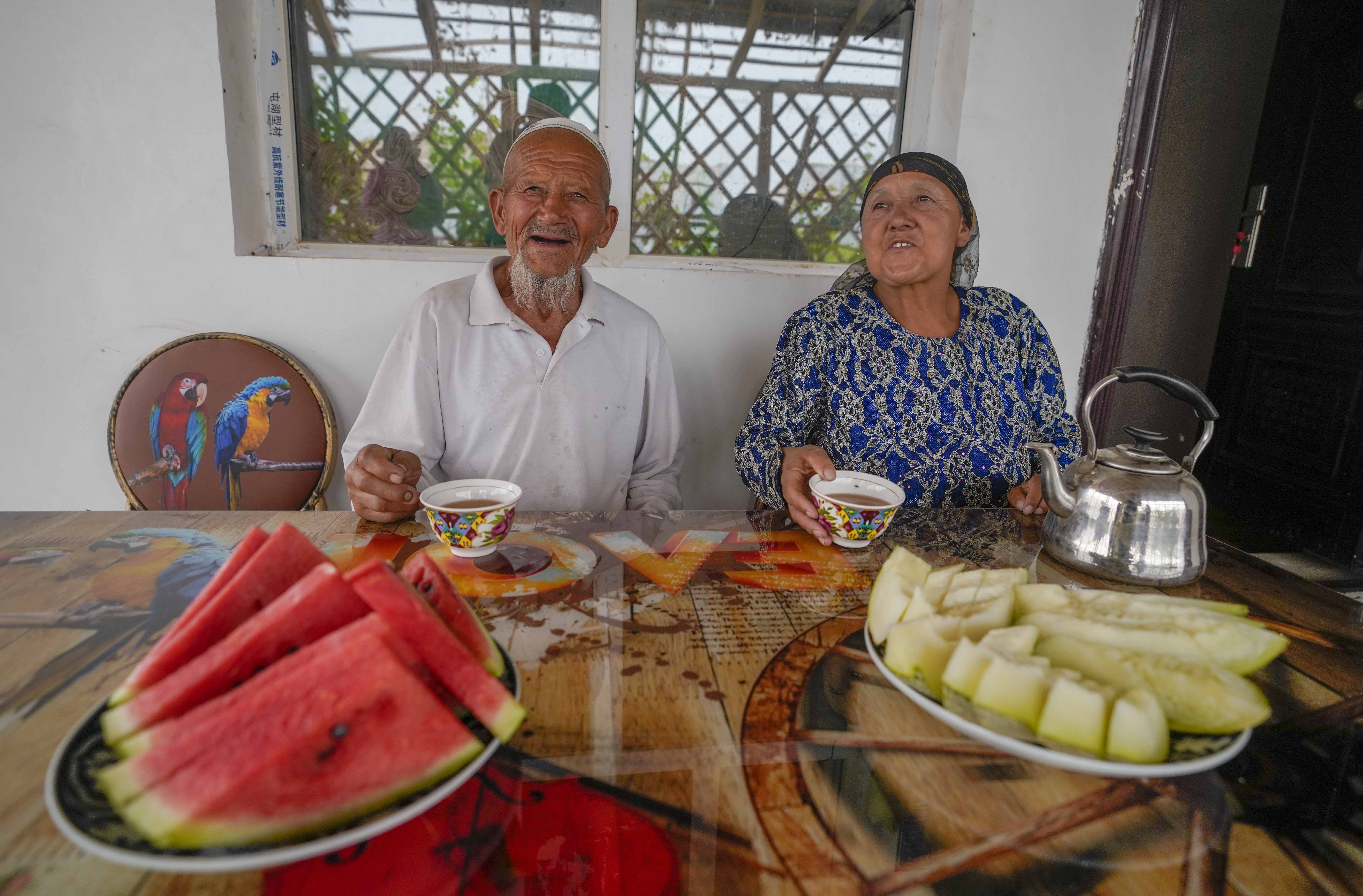 在新疆喀什地區(qū)伽師縣江巴孜鄉(xiāng)依帕克其村57號，80歲的維吾爾族老人伊米提·艾山（左）在自家庭院中（2020年6月8日攝）。