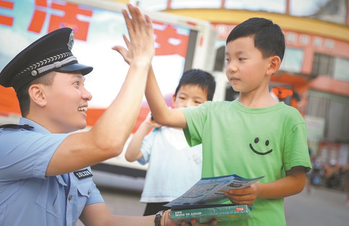 ▲7月10日，江西省吉安市公安局吉州分局組織民警深入轄區(qū)開展安全宣傳，民警向小朋友講解防溺水知識。朱文杰攝