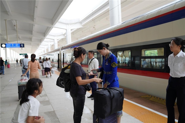 中老鐵路工作人員在站臺(tái)指引旅客進(jìn)站乘車(chē)。老中鐵路有限公司供圖