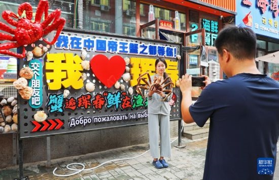 9月21日，游客在吉林省琿春市一處帝王蟹元素主題裝飾前拍照留念。新華社發(fā)