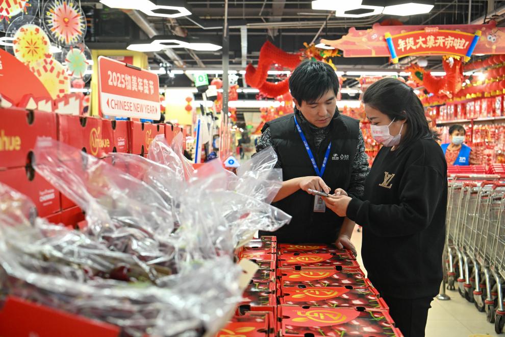 2024年12月26日，在天津市西青區(qū)一家大型商超，工作人員指導(dǎo)顧客線上下單智利車厘子。新華社記者孫凡越攝